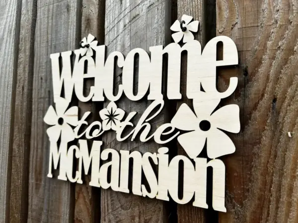 A 300mm personalised welcome sign displays your surname or house name on a fence, adorned with elegant flower designs that beautifully complement the custom text.